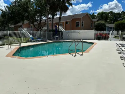 a swimming pool with a slide in a yard at Spacious Condo Close to Disney Attractions in Kissimmee