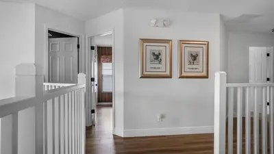 a white hallway with two pictures on the wall at Beautiful 7 Bed Family Pool Home with Game Room-8510PHD in Kissimmee