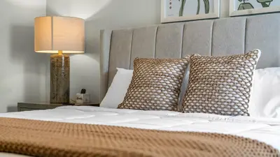 a bedroom with a bed with pillows and a lamp at Beautiful 7 Bed Family Pool Home with Game Room-8510PHD in Kissimmee