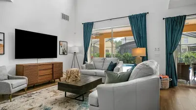 a living room with a tv and a couch and chairs at Beautiful 7 Bed Family Pool Home with Game Room-8510PHD in Kissimmee