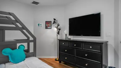 a bedroom with a black dresser with a flat screen tv at Beautiful 7 Bed Family Pool Home with Game Room-8510PHD in Kissimmee