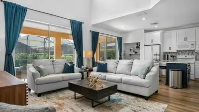 a living room with two couches and a table at Beautiful 7 Bed Family Pool Home with Game Room-8510PHD in Kissimmee