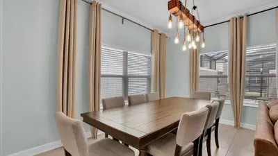 a dining room with a wooden table and chairs at Canoe Landing in Orlando