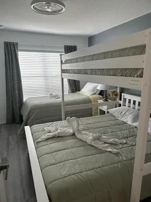 a bedroom with two bunk beds next to a window at Vilas em Seven Dwarfs - 3 Quartos - 20 min disney in Kissimmee