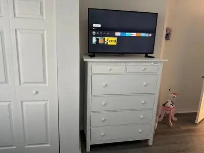 a dresser with a television on top of it at Vilas em Seven Dwarfs - 3 Quartos - 20 min disney in Kissimmee