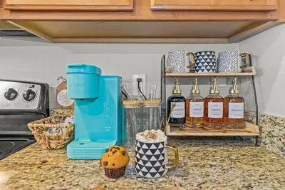 a kitchen counter with a blue juicer and bottles of syrup at Lake view Pool home near Disney - 5BR 4BA in Kissimmee