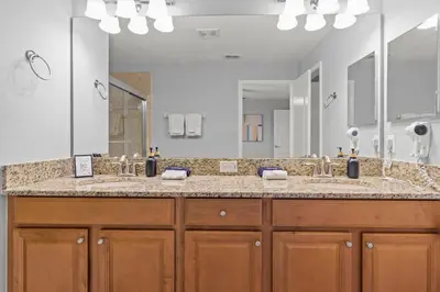 a bathroom with two sinks and a large mirror at Lake view Pool home near Disney - 5BR 4BA in Kissimmee