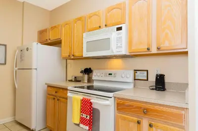 a kitchen with white appliances and wooden cabinets at Cozy Apartment 3BD2BA at Windsor Hills WH28131 in Orlando