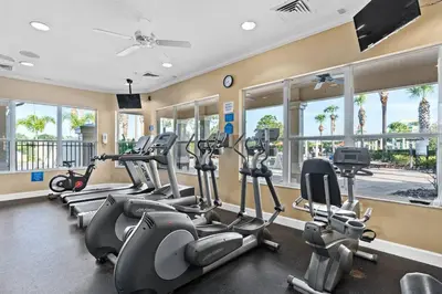 a gym with several treadmills and elliptical machines at Windsor Hills Magic,Resort Waterslides,Pool,Disney in Orlando