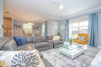 a living room with a couch and a table at Luxury 6BR Resort Home - Pool, Hot Tub & BBQ - Near Disney! in Kissimmee