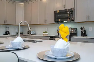 a kitchen with two cups on a counter with a sink at Luxury 6BR Resort Home - Pool, Hot Tub & BBQ - Near Disney! in Kissimmee