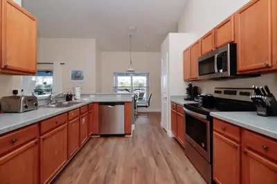 a large kitchen with wooden cabinets and stainless steel appliances at Orange Tree Vacation Home with Private Pool and Spa Near Disney in Orlando