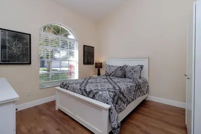 a bedroom with a bed and a window at Orange Tree Vacation Home with Private Pool and Spa Near Disney in Orlando