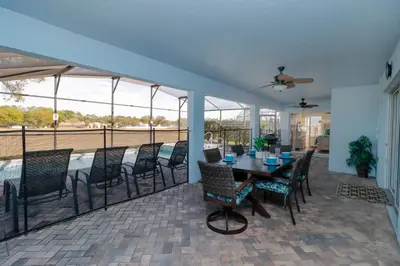a dining room with a table and chairs on a patio at Orange Tree Vacation Home with Private Pool and Spa Near Disney in Orlando