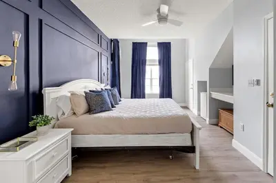 a bedroom with a large bed with blue walls at New Listing Just remodeled 4 BR - ER2739 in Kissimmee