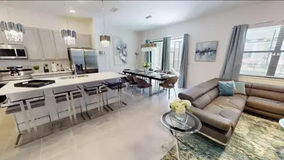 a kitchen and living room with a couch and a table at Paradiso Grande 8BD Games Themed Rooms & Pool Spa in Orlando