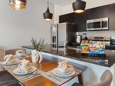 a kitchen with a wooden table with two chairs at 3240 Townhouse Perfect for Disney Visits 3BD in Kissimmee