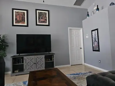 a living room with a flat screen tv on a wall at Minnie Heaven in Kissimmee
