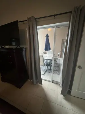 a living room with a sliding glass door with a table at Minnie Heaven in Kissimmee