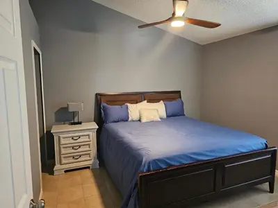 a bedroom with a bed and a ceiling fan at Mufasa's Pride in Kissimmee