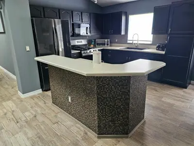 a kitchen with blue cabinets and a white counter top at Mufasa's Pride in Kissimmee