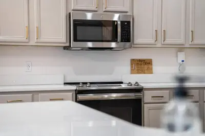 a kitchen with a stove and a microwave at EPIC Theme 9D 360 Rotating Virtual Reality Machine 4 mi to Disney in Kissimmee