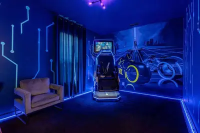 a room with a video game machine and a chair at EPIC Theme 9D 360 Rotating Virtual Reality Machine 4 mi to Disney in Kissimmee