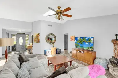 a living room with a couch and a ceiling fan at Tranquil Oasis 4BR Pool Home in Orlando