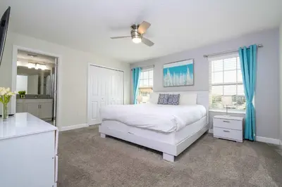 a white bedroom with a bed and a ceiling fan at Stunning 5Bd with Pool at Storey Lake 5019 in Kissimmee