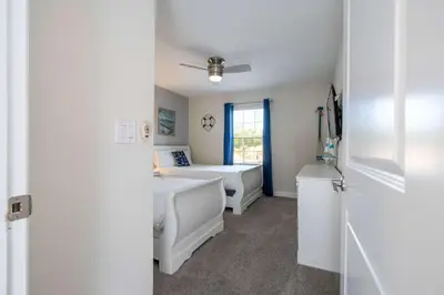 a white bedroom with a bed and a window at Stunning 5Bd with Pool at Storey Lake 5019 in Kissimmee