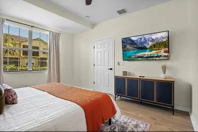a bedroom with a bed and a tv on the wall at Disney Paradise-Family Friendly- Near to Disney in Orlando