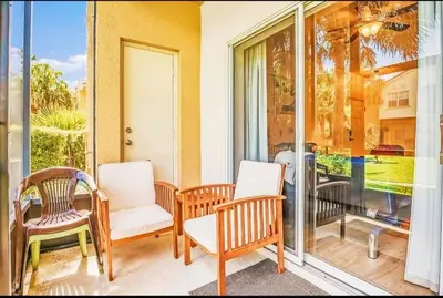 a porch with chairs and a sliding glass door at Disney Paradise-Family Friendly- Near to Disney in Orlando