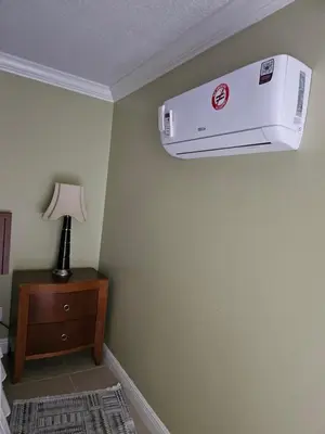 a hotel room with a air conditioner hanging from a wall at Pretige Studio in Orlando