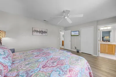 a bedroom with a bed and a ceiling fan at Camaro in Orlando