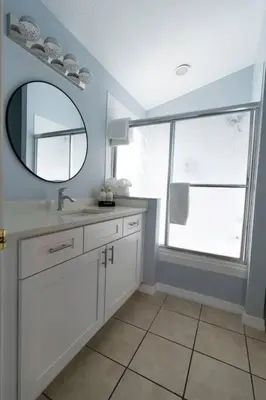 a bathroom with a sink and a mirror and a window at Disney World Vacation Home in Orlando