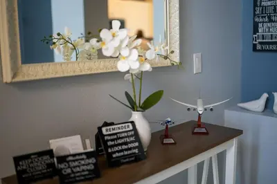 a table with a vase with white flowers on it at Disney World Vacation Home in Orlando