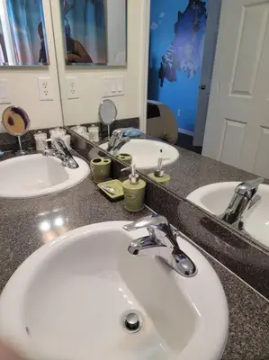 a bathroom counter with two sinks and a mirror at Amazing Star Wars & Disney Vr Gaming House! in Kissimmee