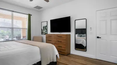a bedroom with a bed and a flat screen tv at Lovely 7 Bed Pool Home with Game Room-8510PHD home in Kissimmee