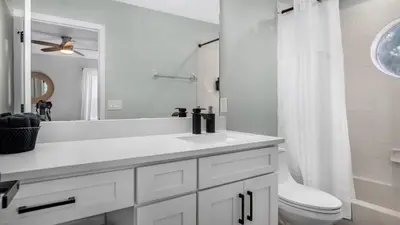a white bathroom with a sink and a toilet at Lovely 7 Bed Pool Home with Game Room-8510PHD home in Kissimmee