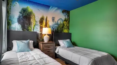 a bedroom with two beds and a painting on the wall at Lovely 7 Bed Pool Home with Game Room-8510PHD home in Kissimmee