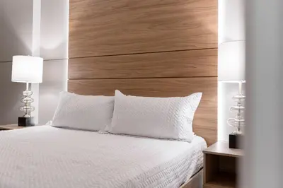 a bedroom with a white bed with a wooden headboard at Brand NEW 12Bed12Bath At Paradiso Grande in Orlando