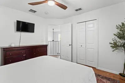 a bedroom with a white bed and a ceiling fan at 7BR Family Friendly Resort Pool Home Near Disney World in Kissimmee