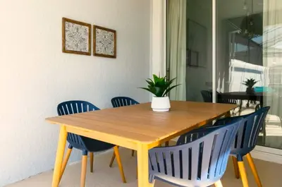 a wooden table with blue chairs and a plant on it at Your 4-Bedroom Getaway, Only 9 Miles from Disney in Kissimmee