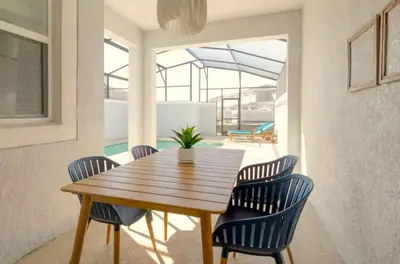 a dining room with a wooden table and blue chairs at Your 4-Bedroom Getaway, Only 9 Miles from Disney in Kissimmee