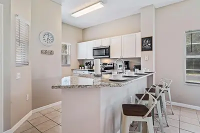 a kitchen with a breakfast bar with stools at 8400 Blue Lagoon Drive in Kissimmee