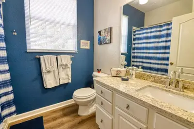 a blue bathroom with a toilet and a sink at Amazing Condo in Windsor Hills Close to Disney in Orlando