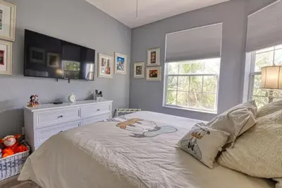 a bedroom with a bed with a dresser and a window at Amazing Condo in Windsor Hills Close to Disney in Orlando