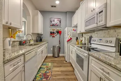 a kitchen with white cabinets and white appliances at Amazing Condo in Windsor Hills Close to Disney in Orlando