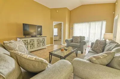 a living room with couches and a flat screen tv at 9 Miles to Disney - Family Friendly - Private Pool in Orlando