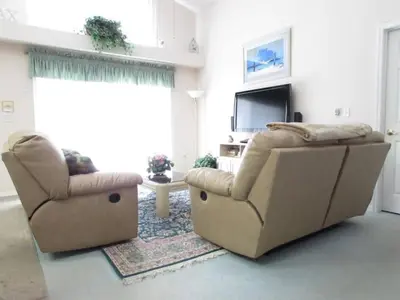 a living room with two chairs and a television at Creekside Kissimmee in Kissimmee